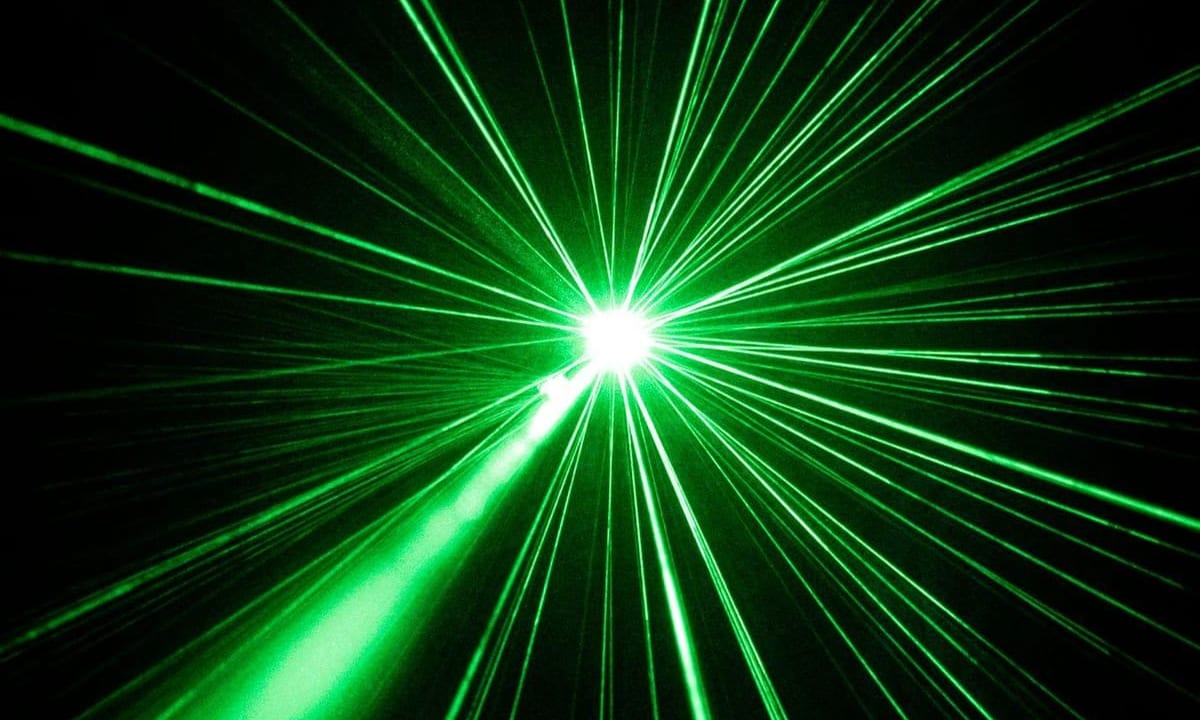 Faisceaux laser verts rayonnant depuis un point de focalisation